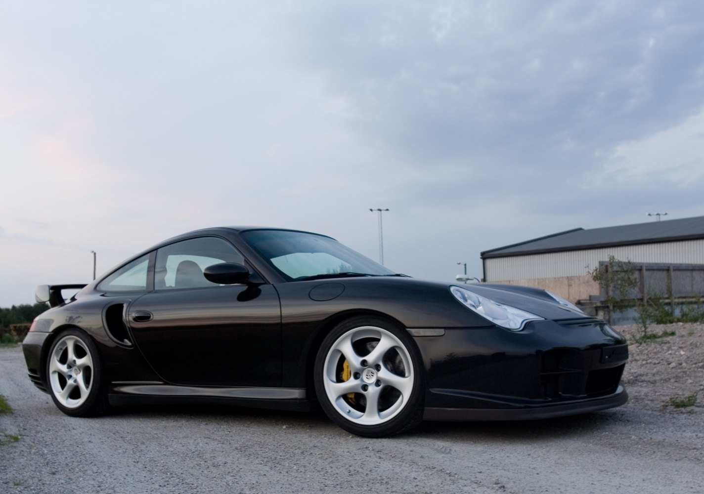 Side profile of sports coupe with rear wing and alloy wheels