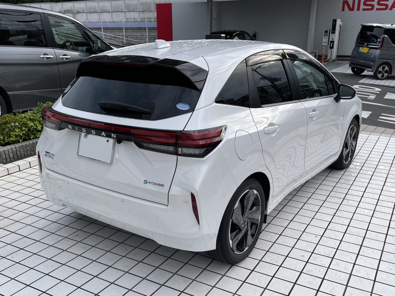 Rear and side view of a white compact hatchback with distinct taillight design and aerodynamic features.