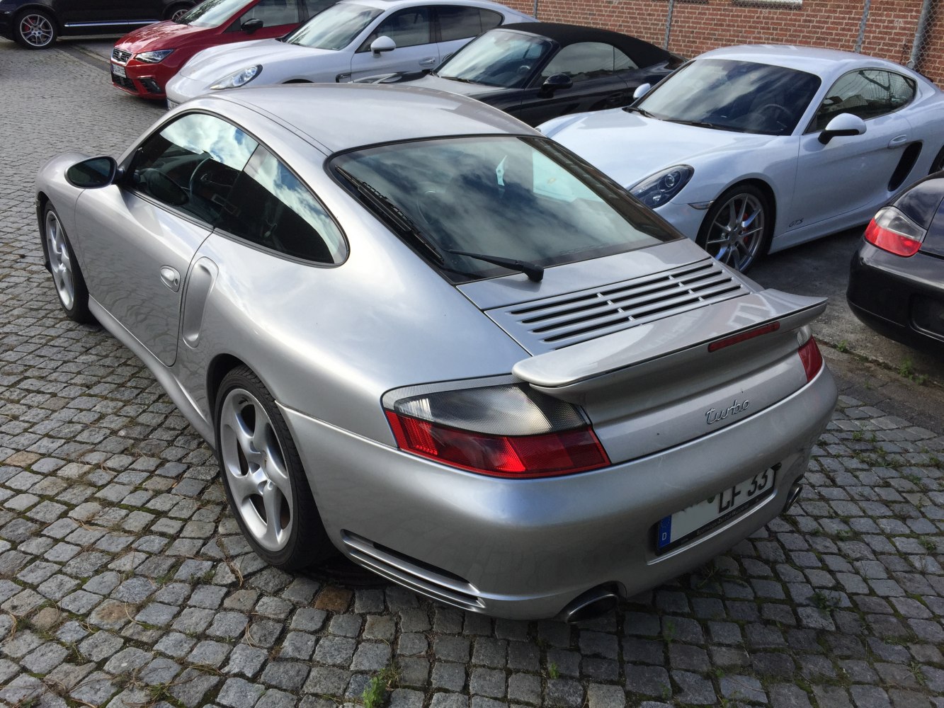 Rear view with spoiler, rear air vents, curved window, and dual exhaust