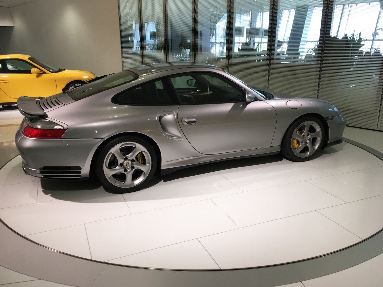 Silver sports coupe side profile with rear wing and alloy wheels