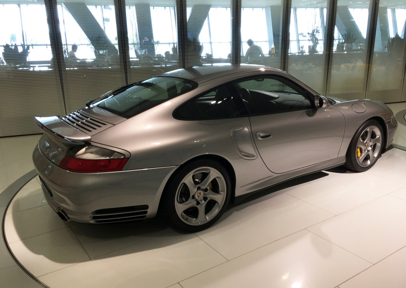 Silver 2002 sports coupe rear side view with spoiler and distinct wheel design