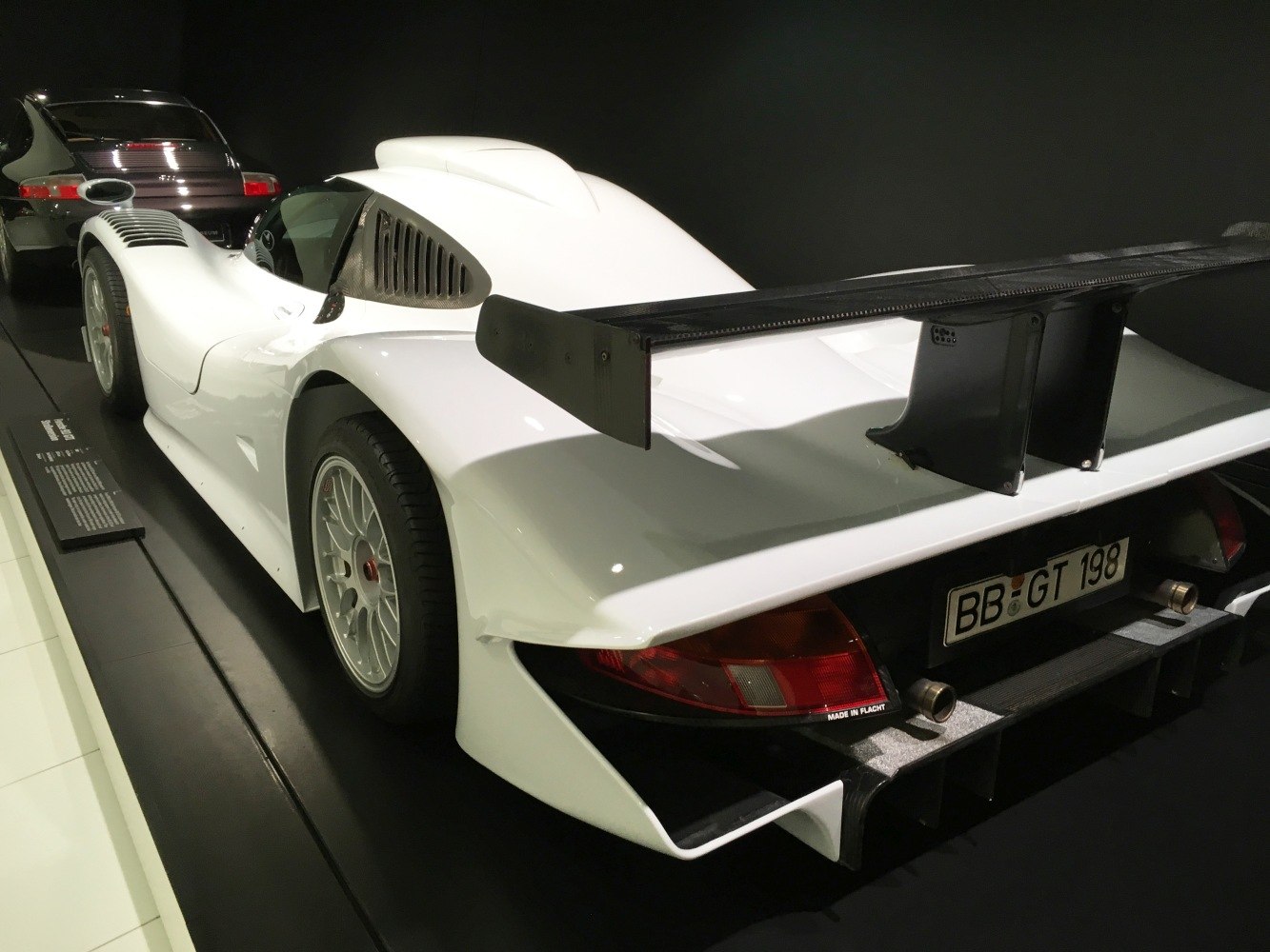 Rear wing and dual exhaust of white sports car