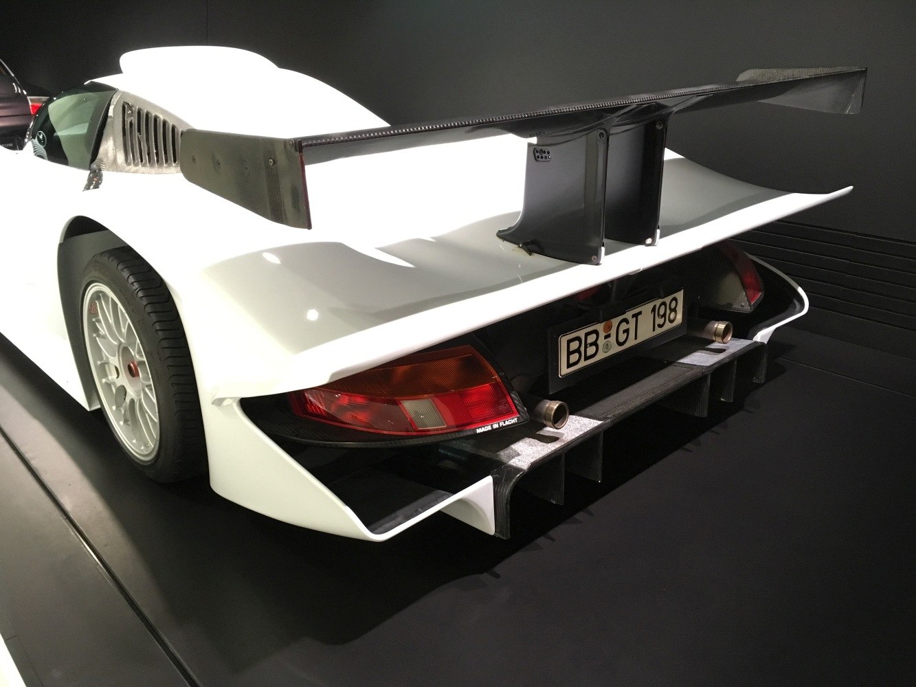 Wide rear spoiler and dual exhausts on a high-performance sports car rear