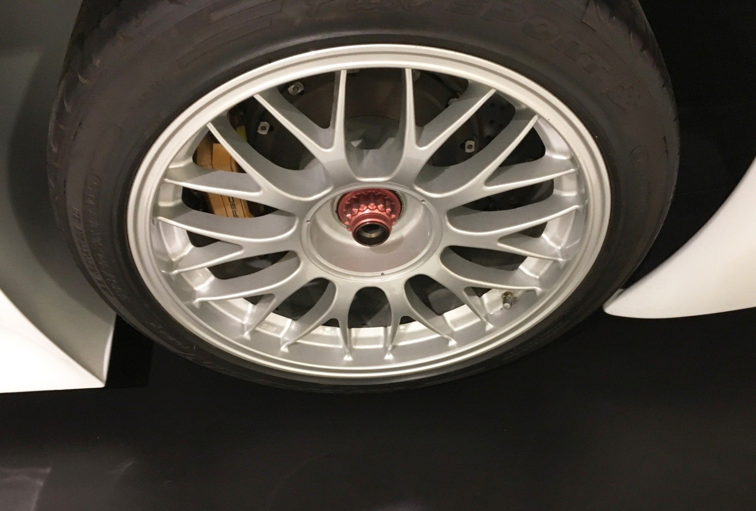 Multi-spoke alloy racing wheel with visible brake caliper