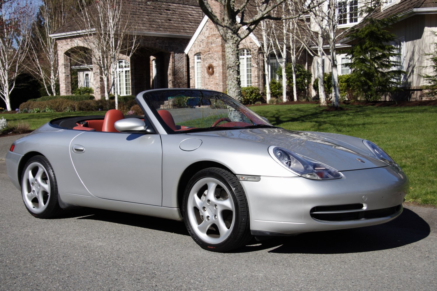 Silver convertible sports car with aerodynamic design and red interior