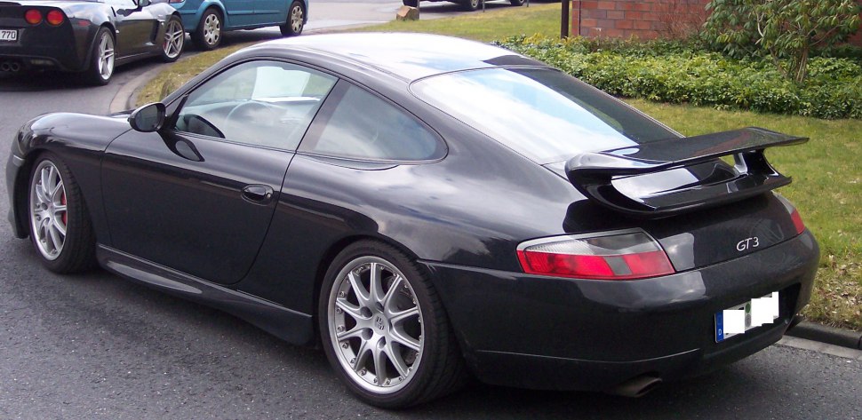 Rear and side view of a black sports coupe with prominent spoiler and alloy wheels