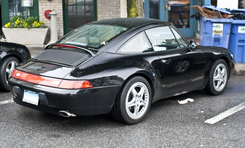 Rear and side view of black 1996 Porsche 911 Targa with sloping roofline and iconic taillights