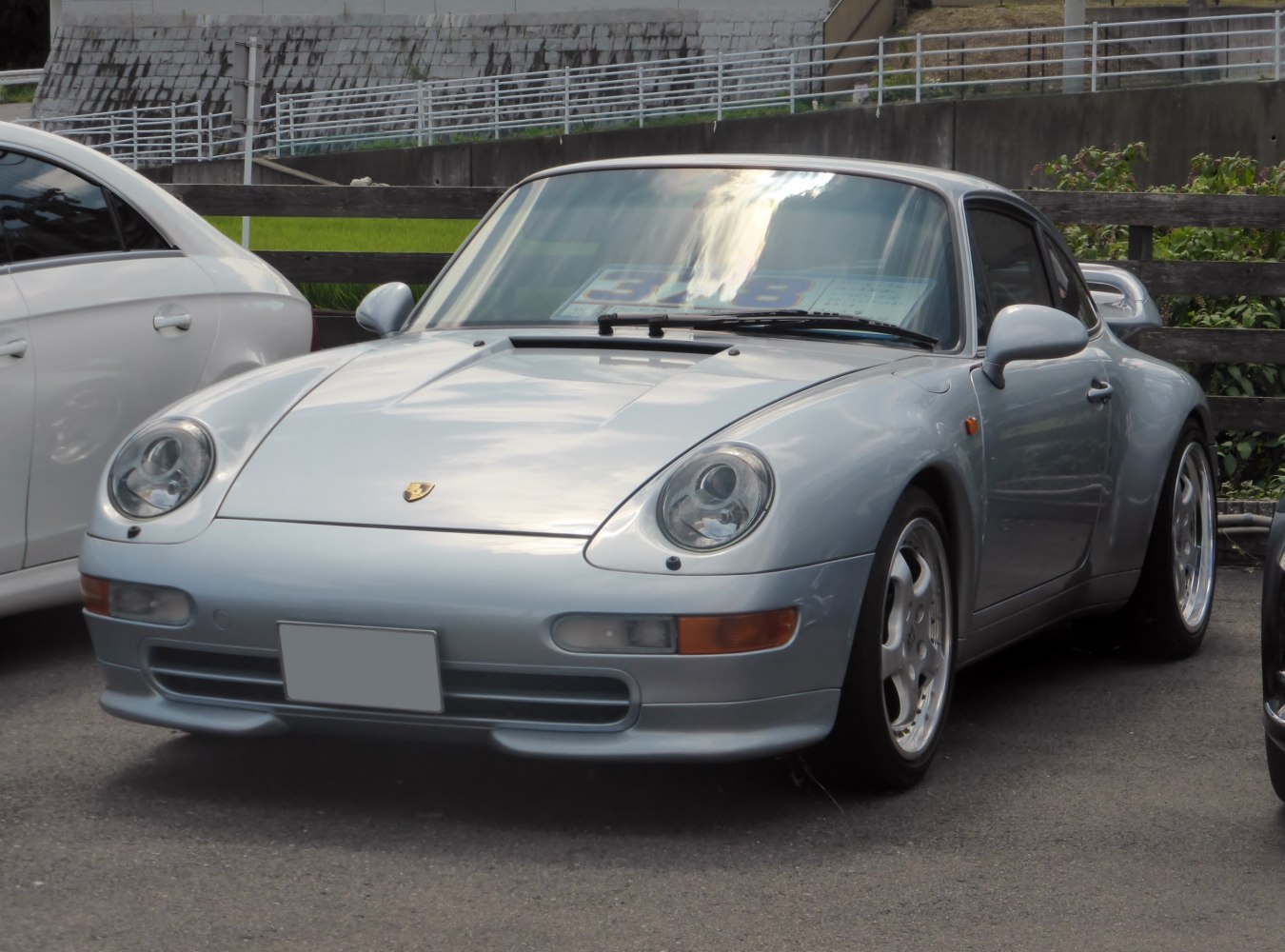 Front view of silver sports coupe with round headlights and classic sleek design