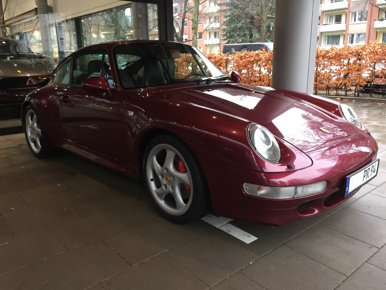 Front and side view with rounded headlights and sleek coupe body