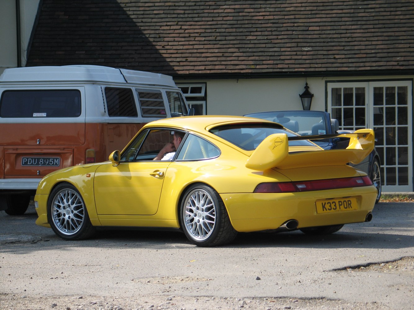 Yellow sports coupe with large rear wing and multi-spoke alloy wheels.