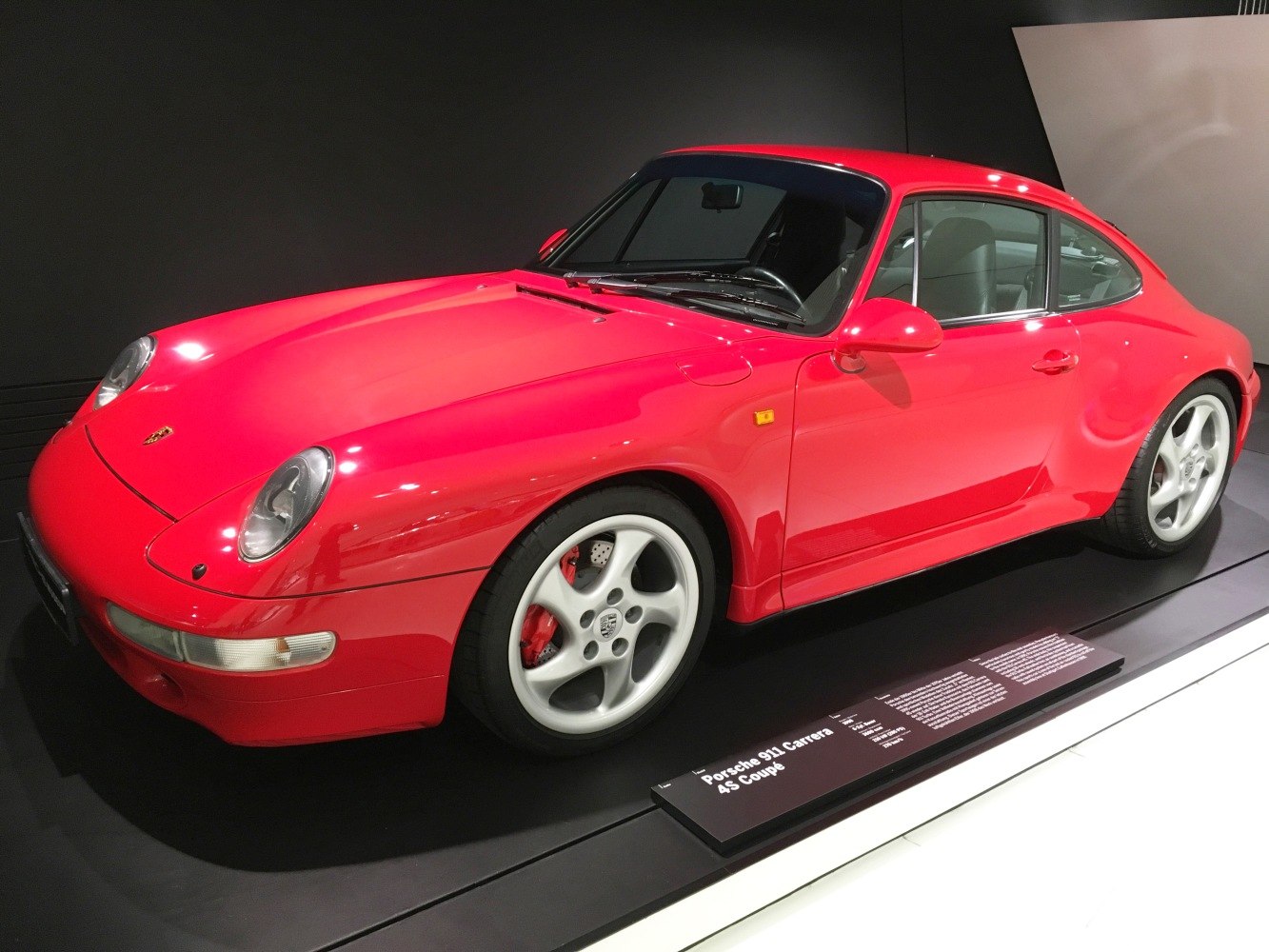 Red coupe with rounded headlights and classic 5-spoke wheels