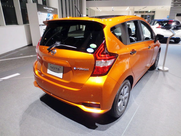Rear three-quarter view of orange hatchback with unique tail lights