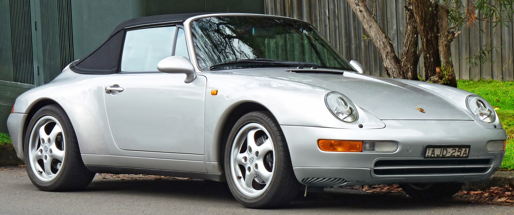 Silver convertible car with soft top and iconic round headlights