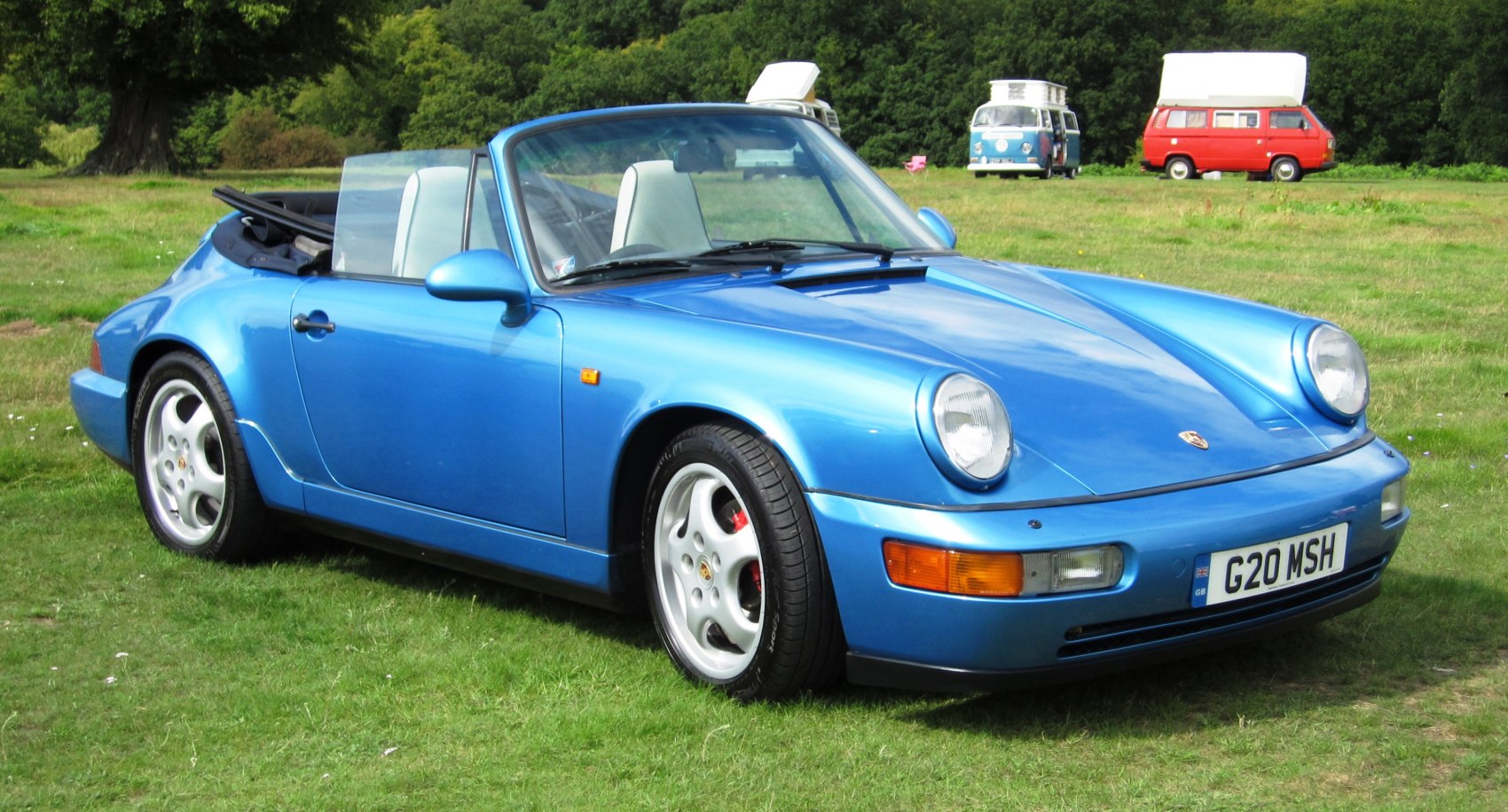 Blue Porsche 964 Cabriolet convertible, front and side view, with round headlights and alloy wheels