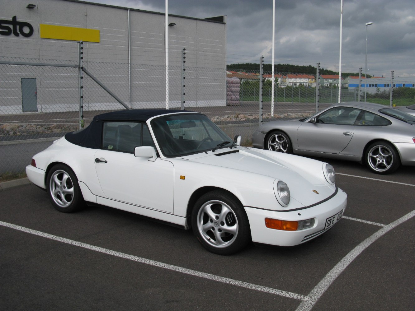 White convertible with round headlights and black soft-top roof