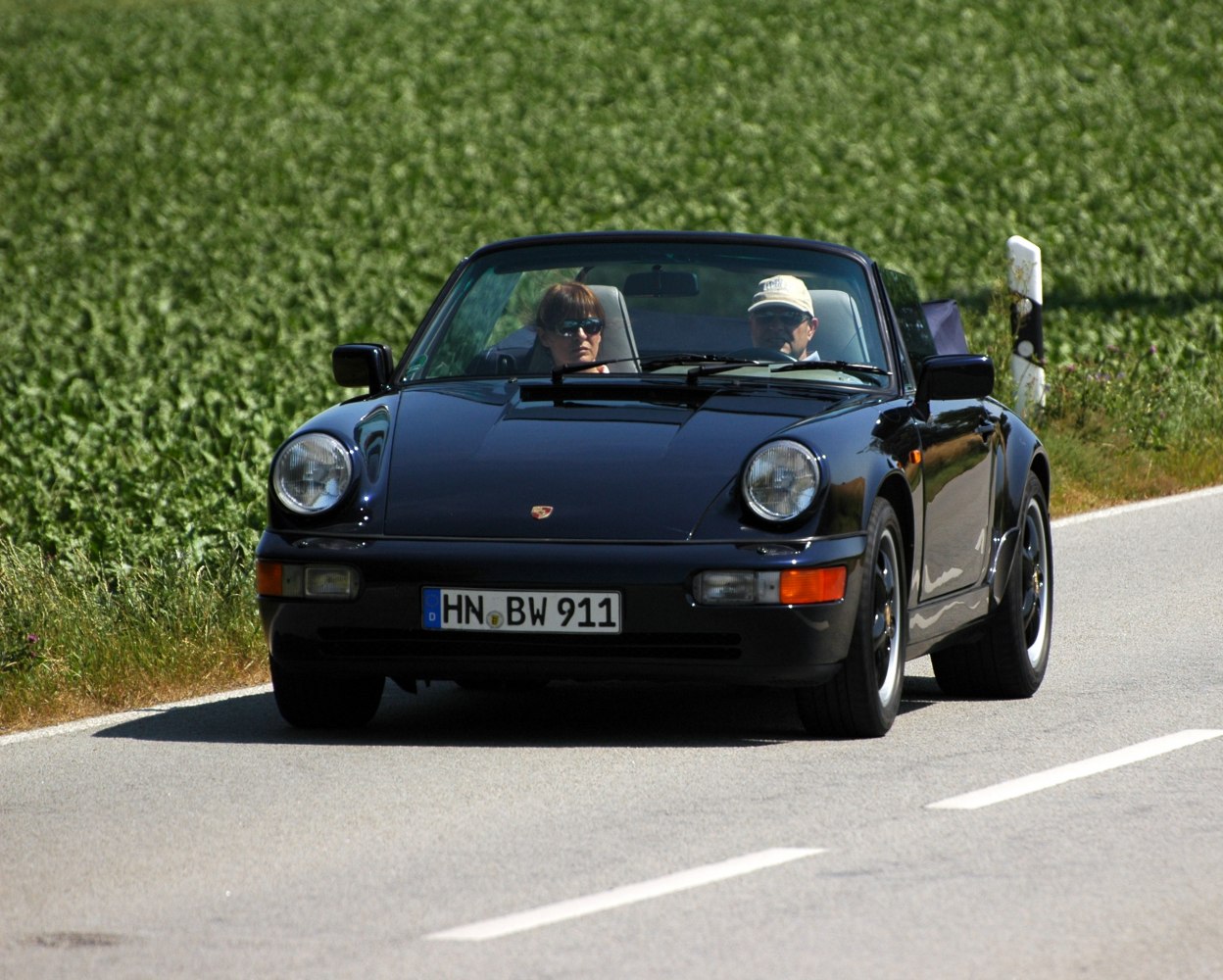 Front view of a classic convertible with open roof and round headlights