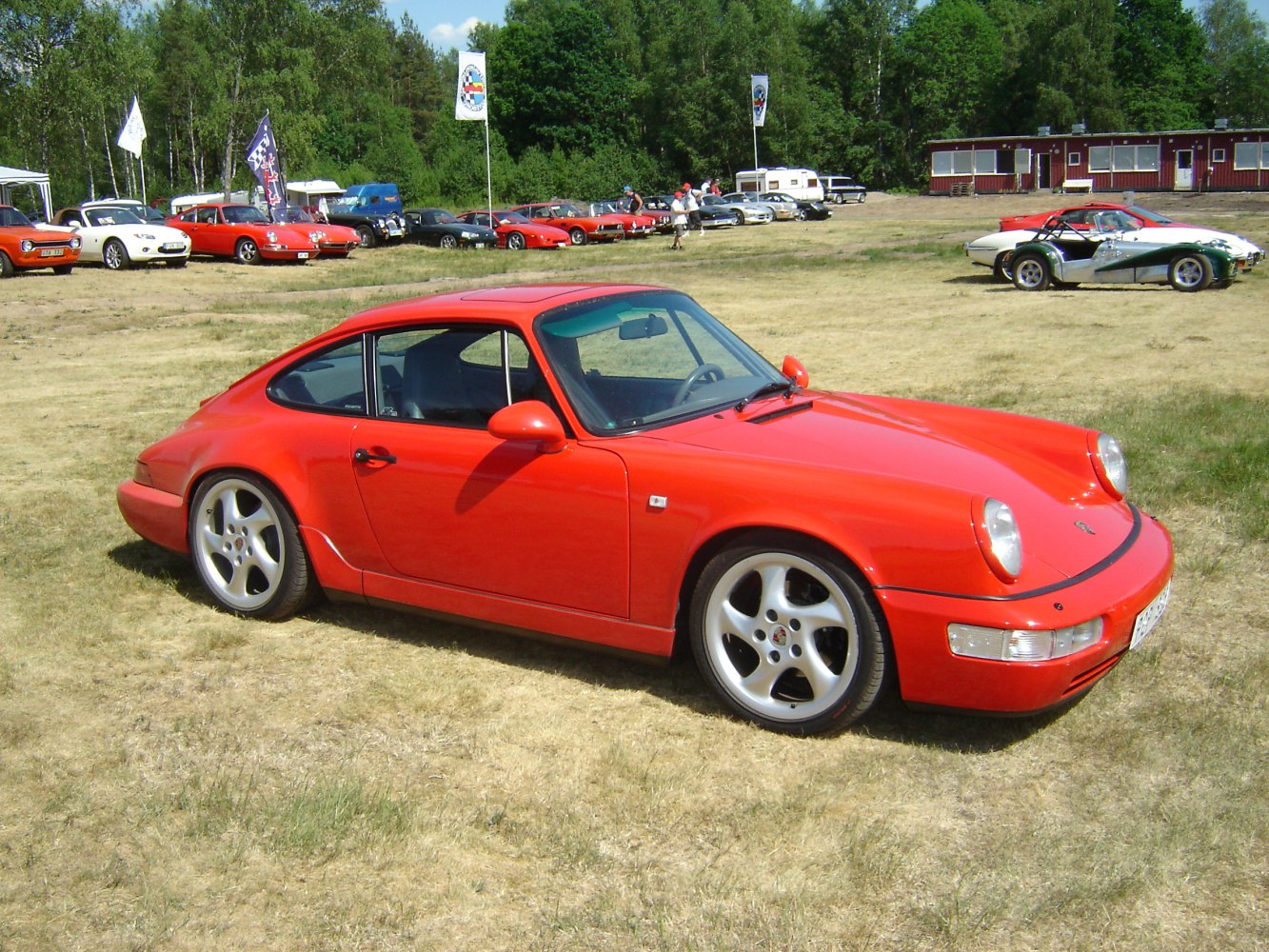 Red coupe with rounded headlights and five-spoke wheels