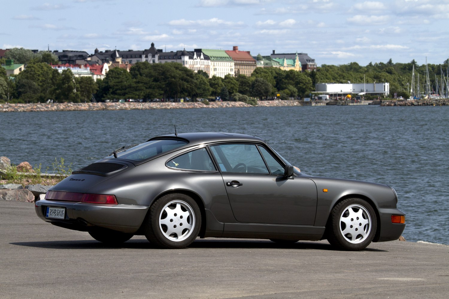 Side profile of a classic 1990s coupe with distinct five-spoke wheels.