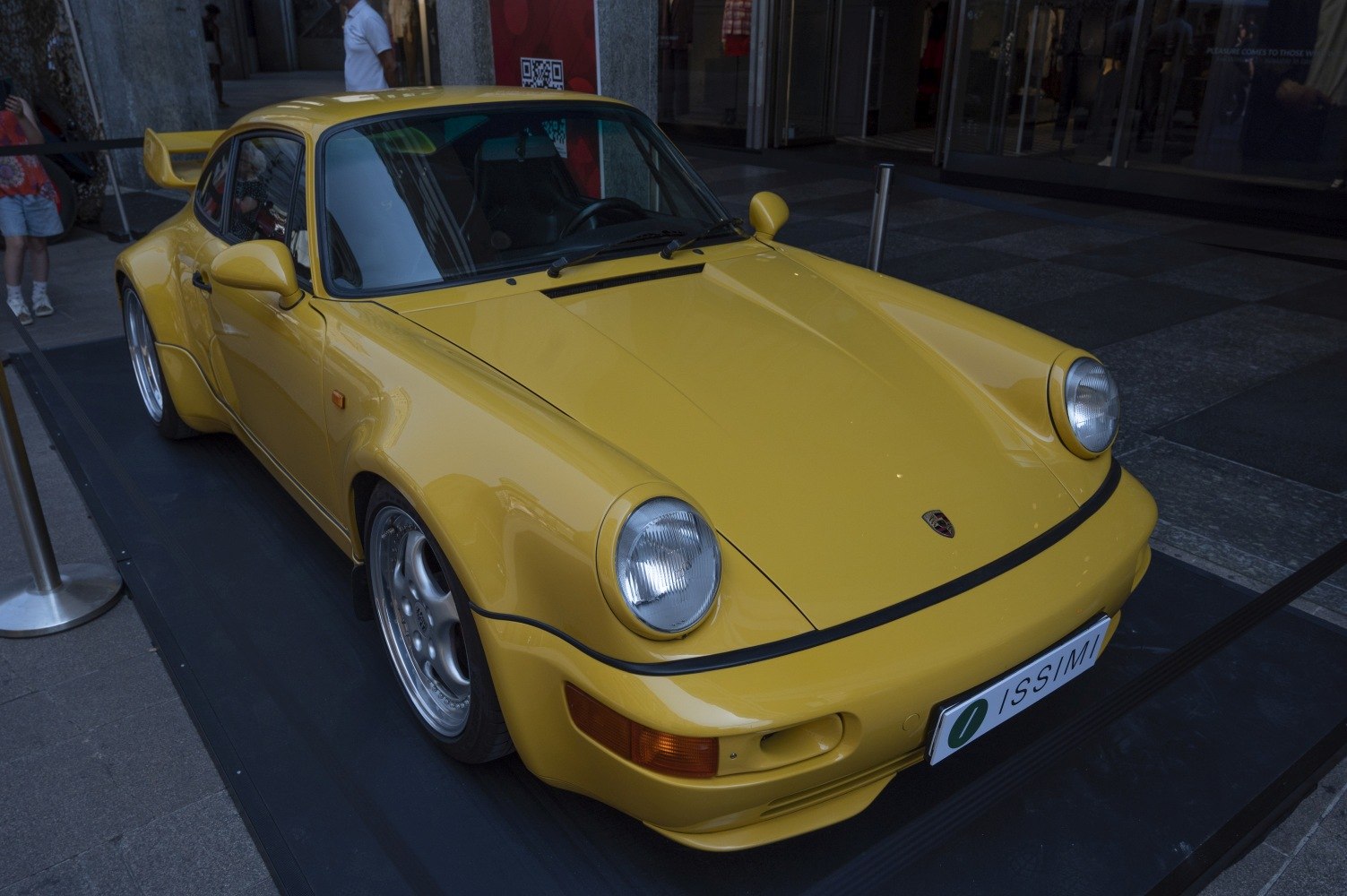 Yellow sports car with wide body fenders and rear wing