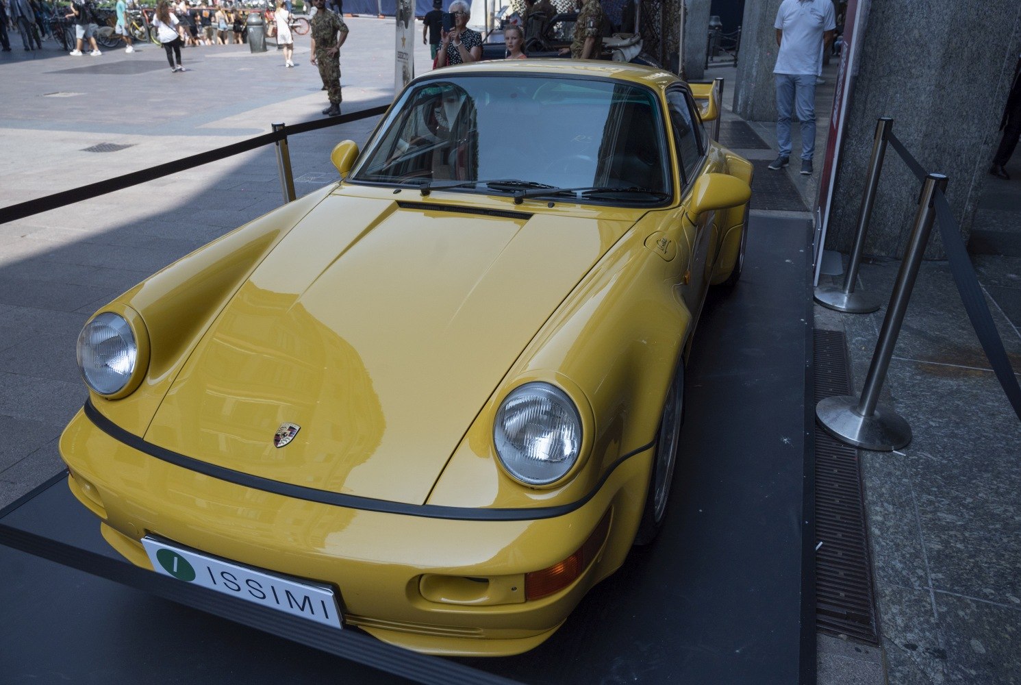 Yellow classic sports car front with round headlights and sleek hood