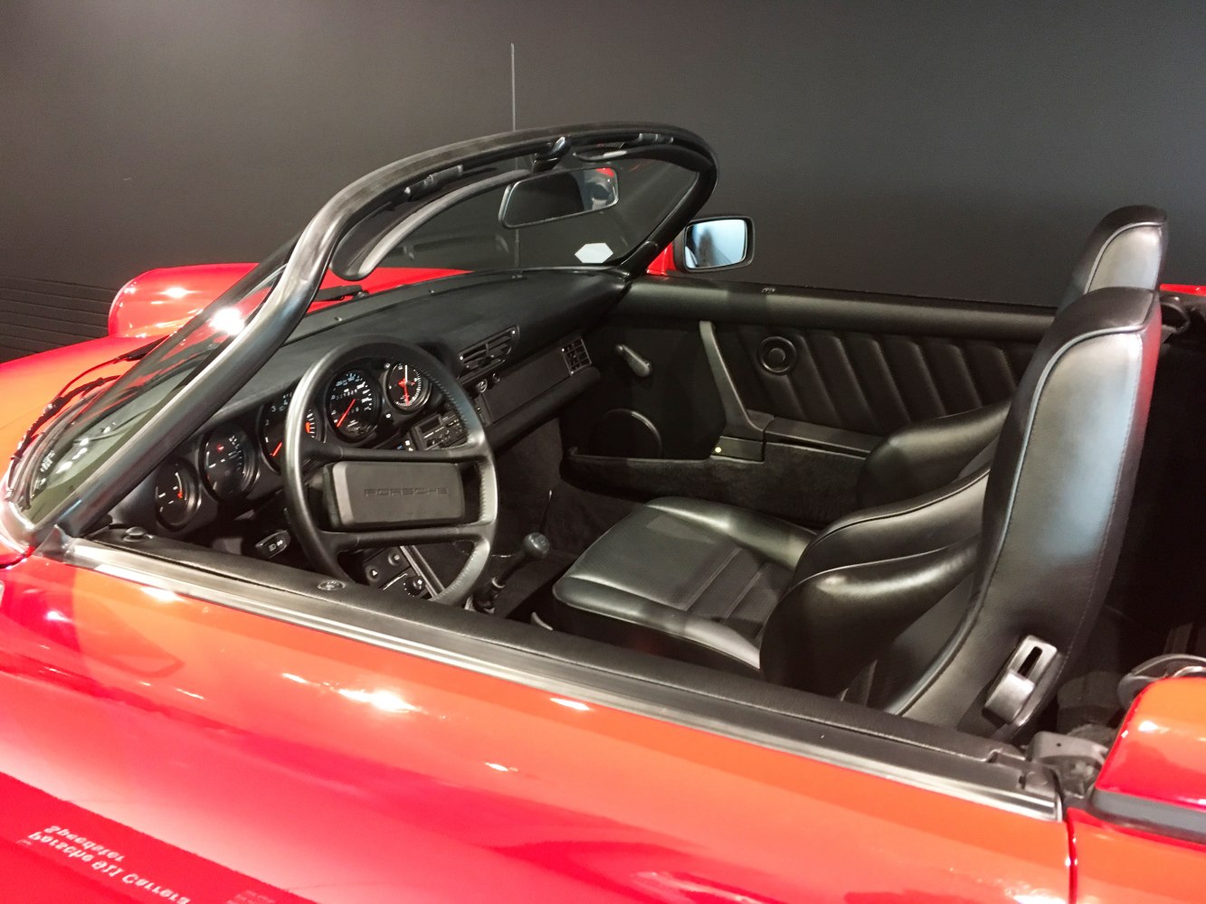 Convertible interior with black leather seats and detailed dashboard.