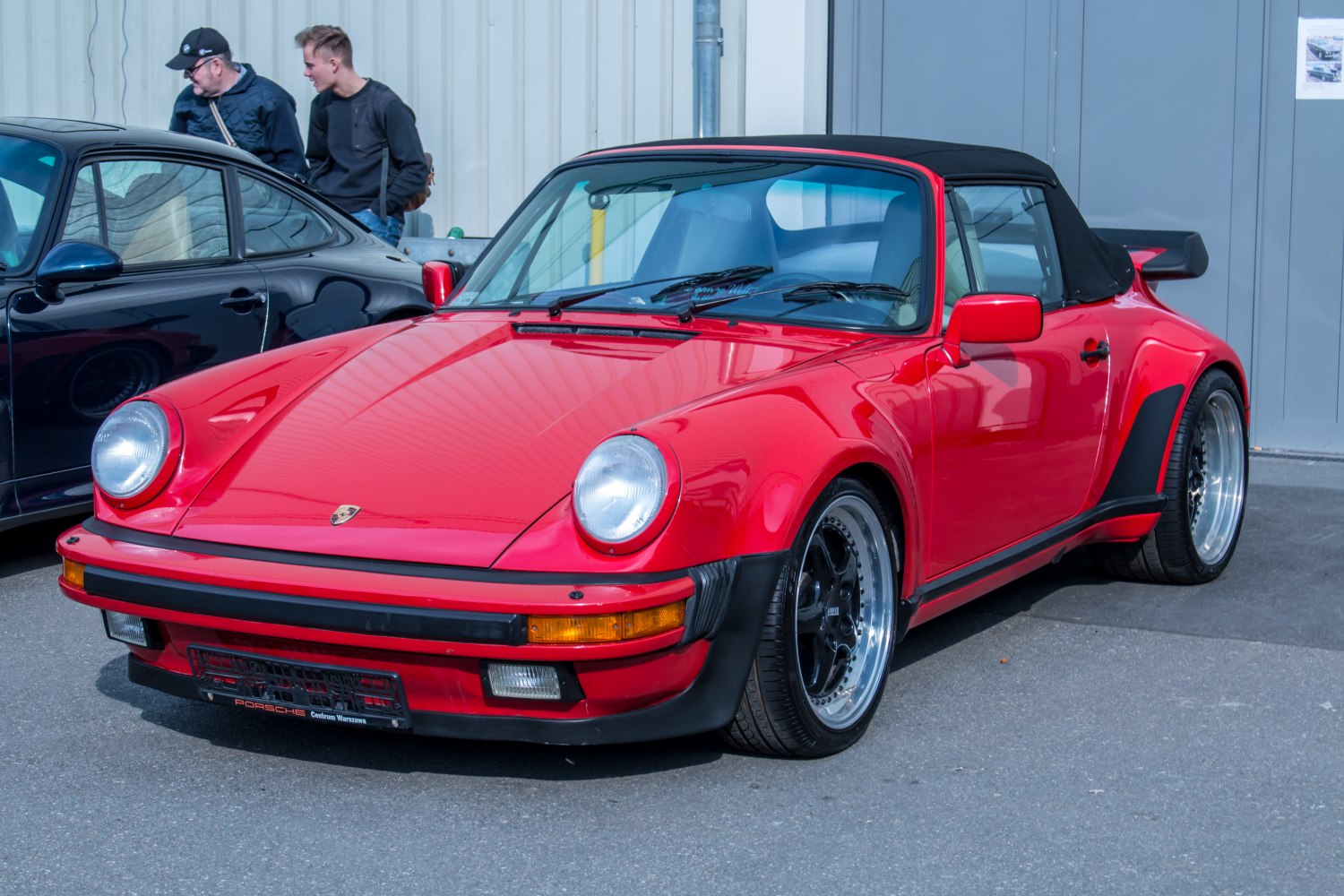 Red convertible with black soft top and wide rear fenders.