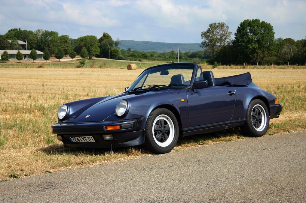 Convertible soft top sports car with classic aerodynamic design and Fuchs style wheels