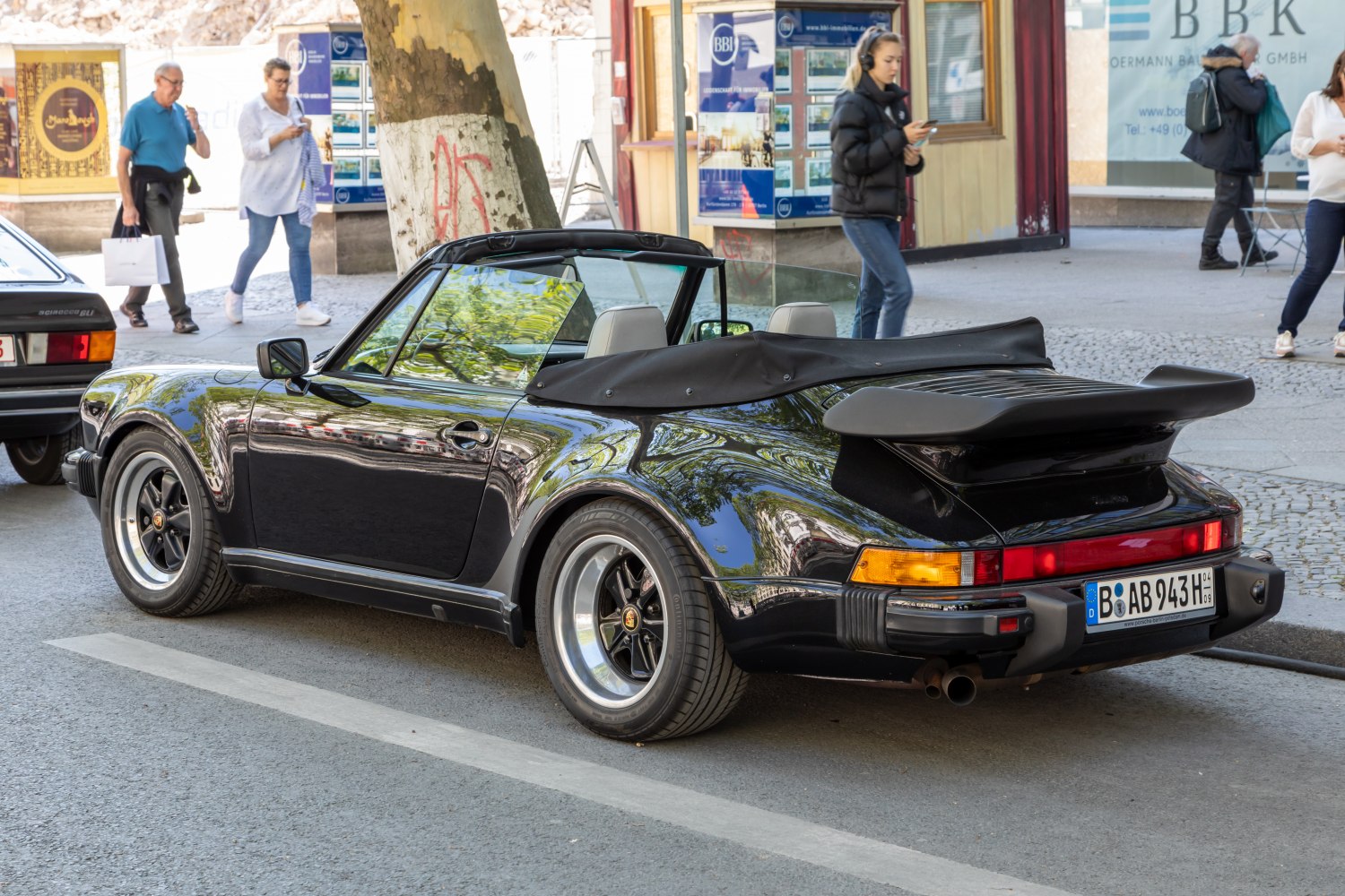 Black convertible sports car with rear spoiler and soft top roof