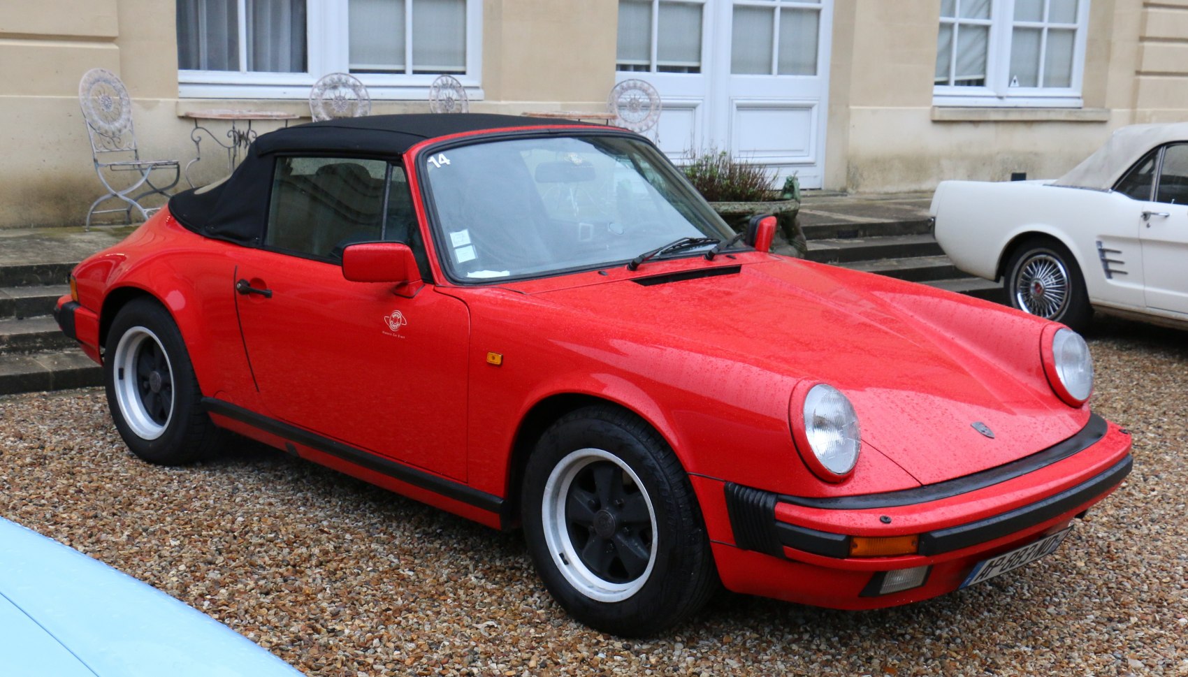 Red classic convertible with soft top and five-spoke wheels