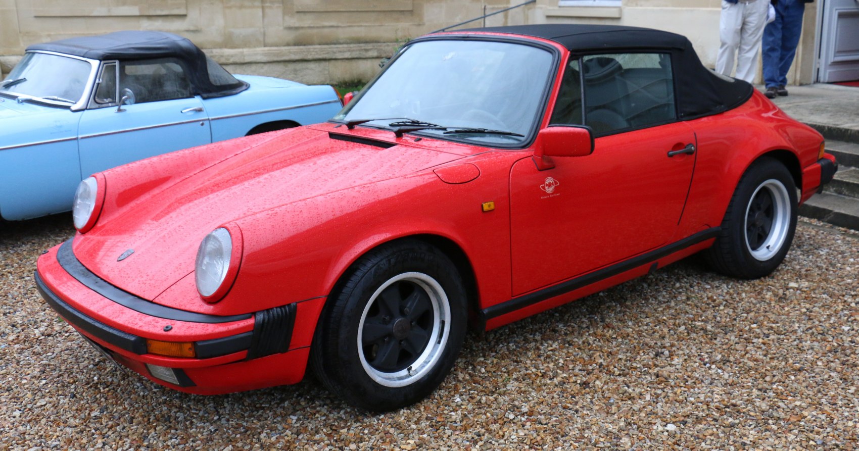 Convertible sports car with black soft top and round headlights
