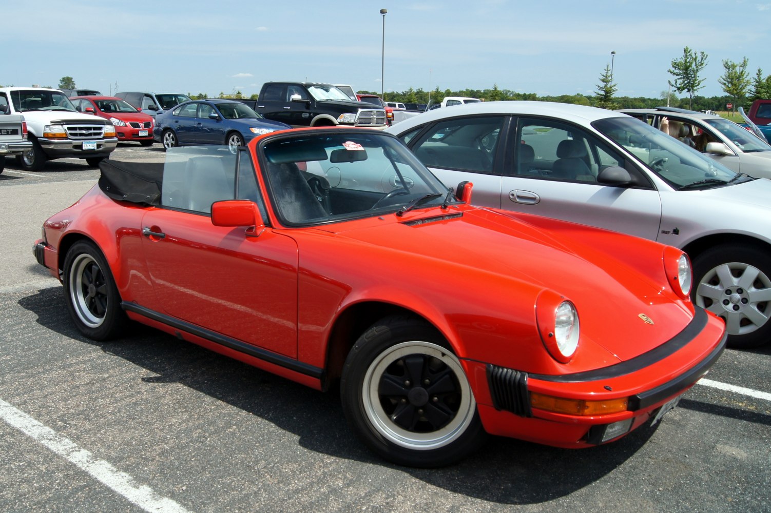 Red convertible sports coupe with pop-up headlights and black rims