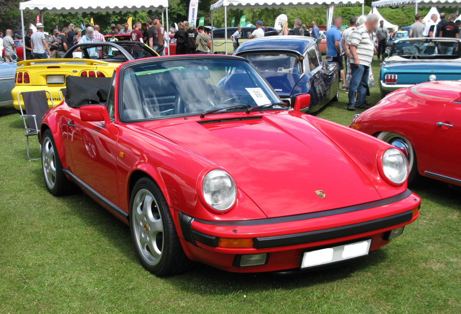 Red convertible sports car with round headlights and five-spoke wheels