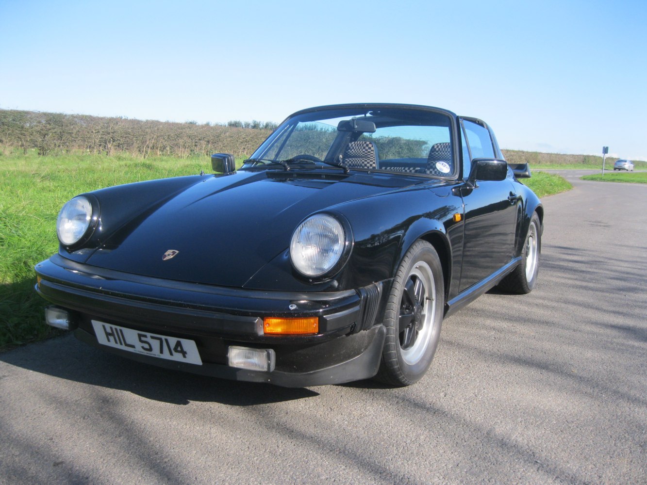 Black Targa convertible with round headlights and checkered seats.