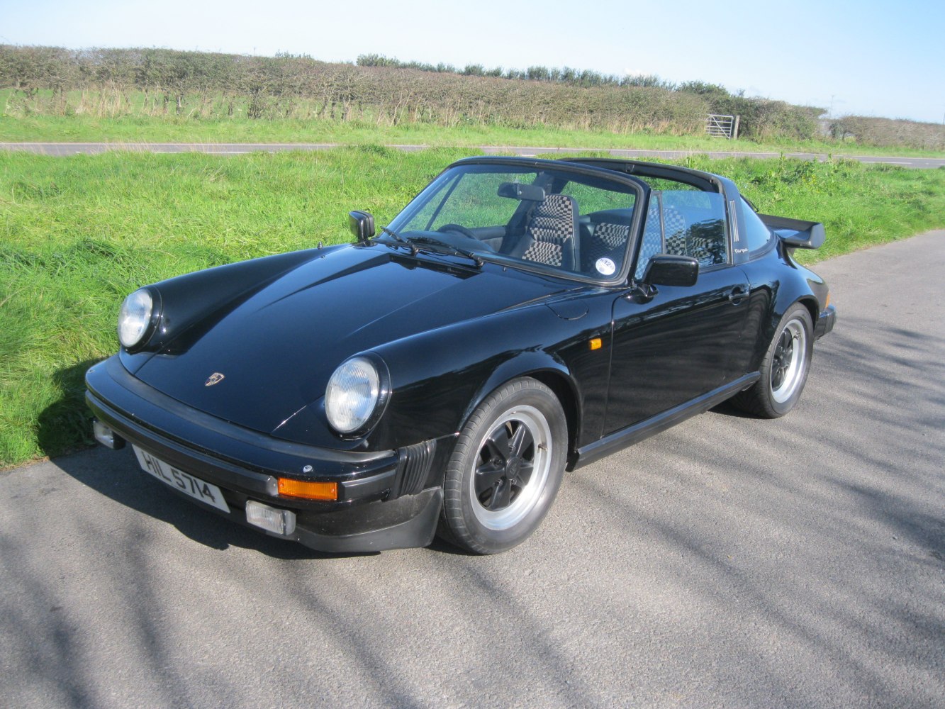 Black Porsche 911 Targa with round headlights and Targa roof