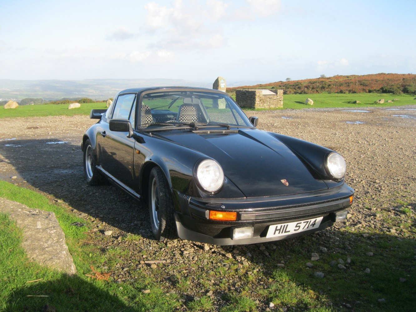 Vintage sports car with round headlights and Targa-style roof