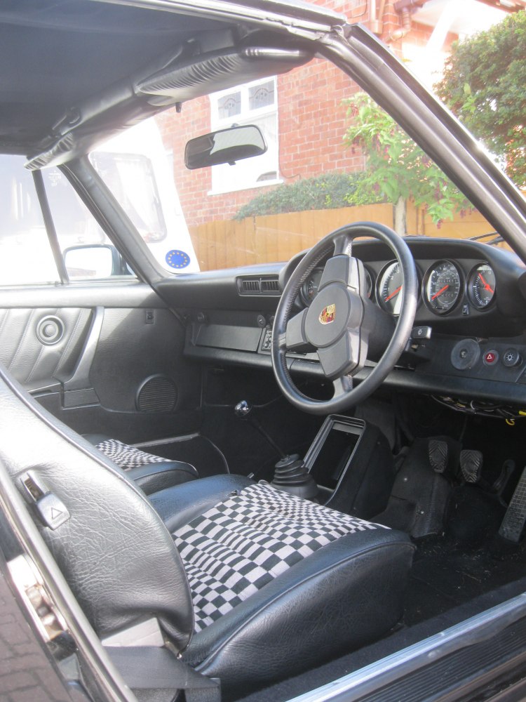 Vintage sports car classic three-spoke steering wheel with checkered seat covers