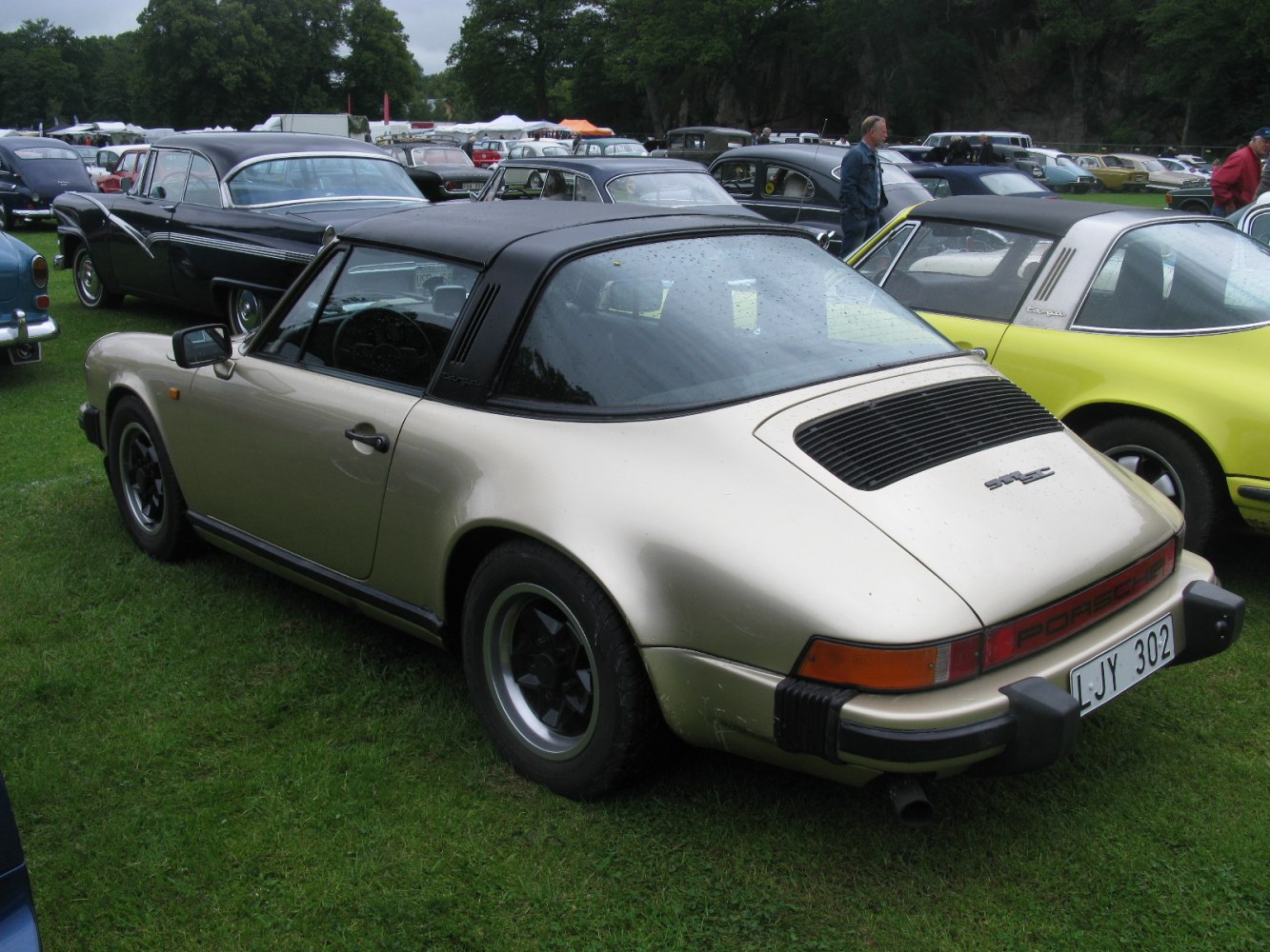 Rear engine vent and iconic Targa roof design on a classic sports car.