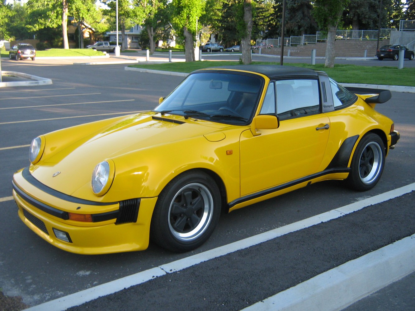 Yellow classic sports car with targa roof and rear spoiler