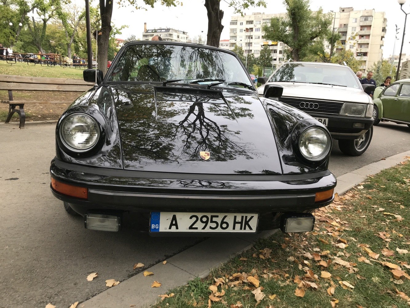 Front view of a vintage sports car with round headlights and sleek hood.