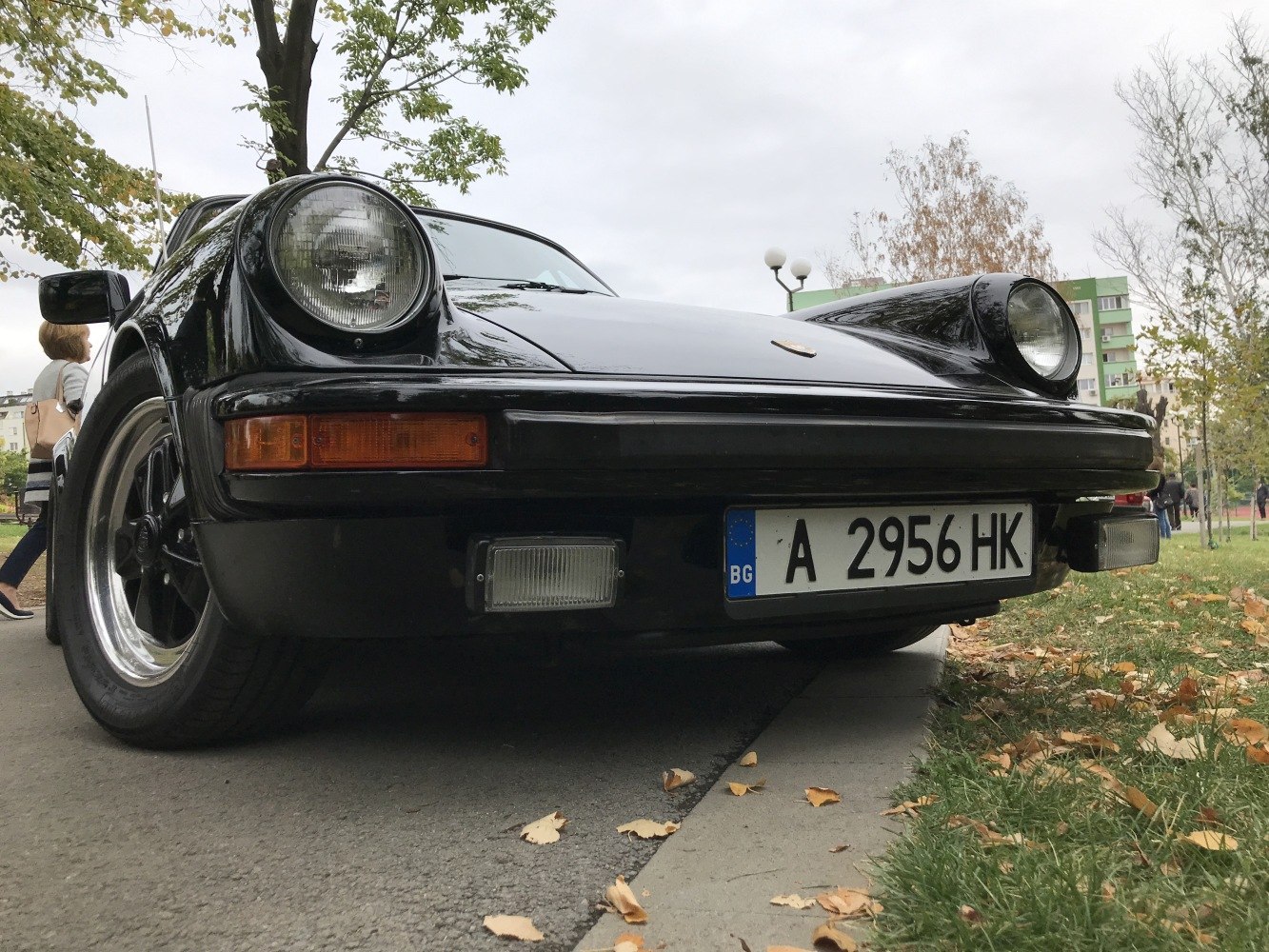 Close-up of classic car front with round headlights and black body.