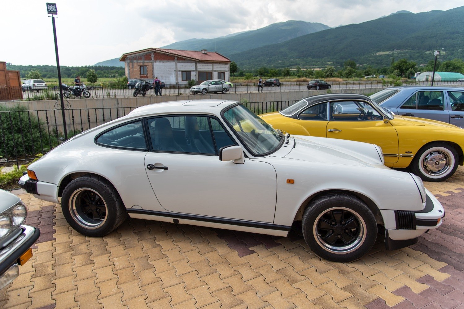White Porsche 911 Coupe (G) with black Fuchs wheels, side view