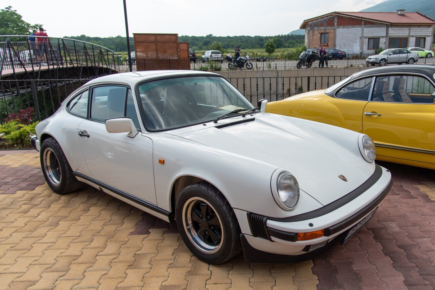 White Porsche 911 Coupe (G) front side view with round headlights