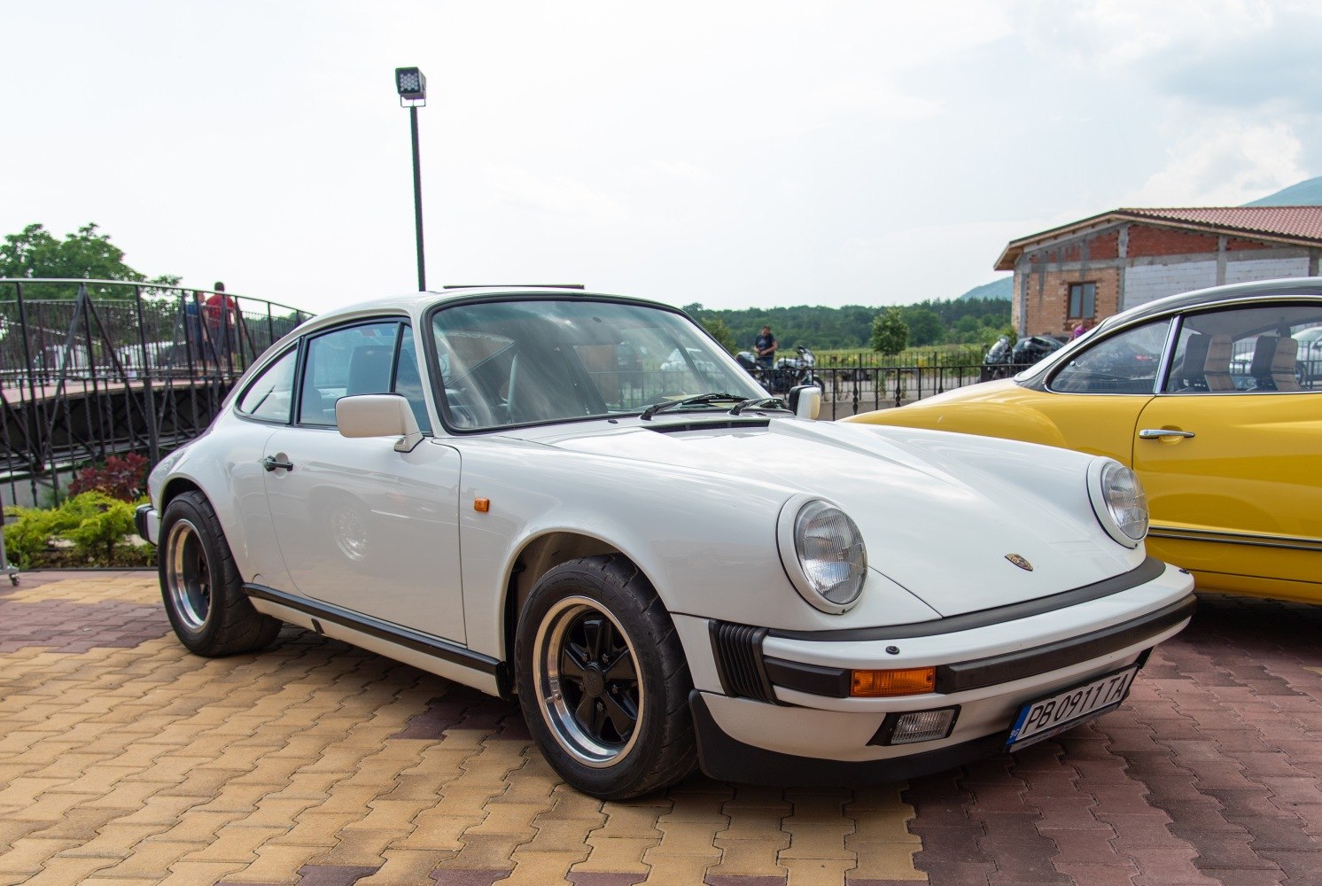 Vintage white sports coupe with round headlights and black alloy wheels