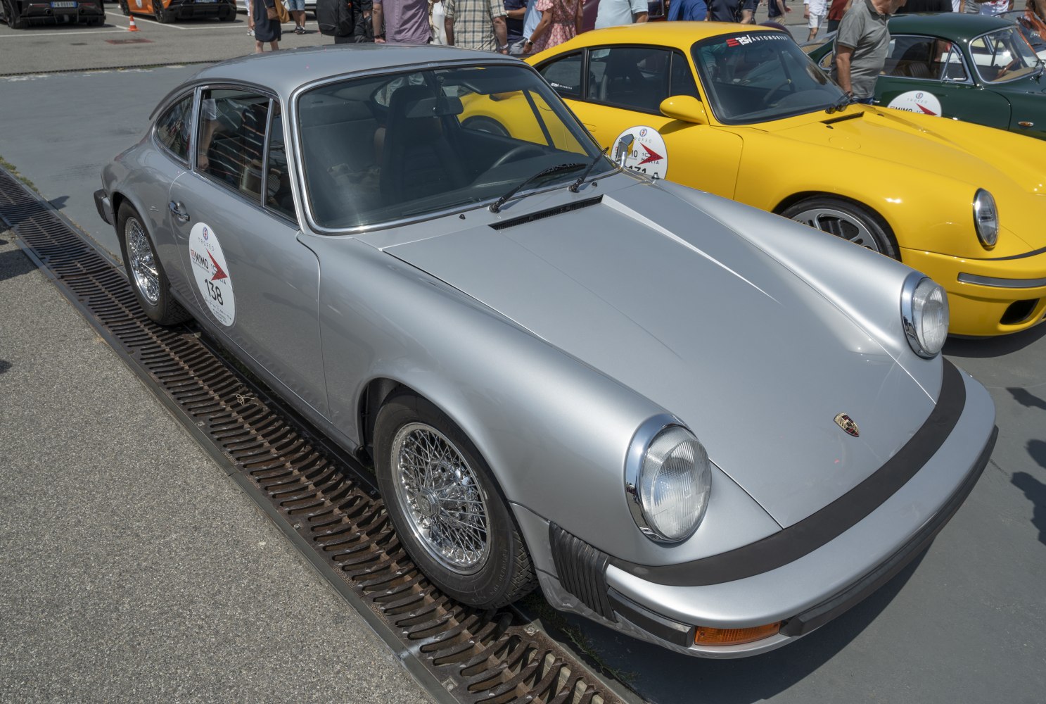 Silver classic sports coupe with wire spoke wheels and round headlights