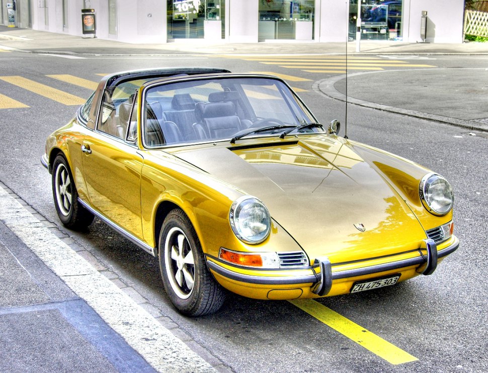 Golden Targa convertible with round headlights and iconic roll bar.