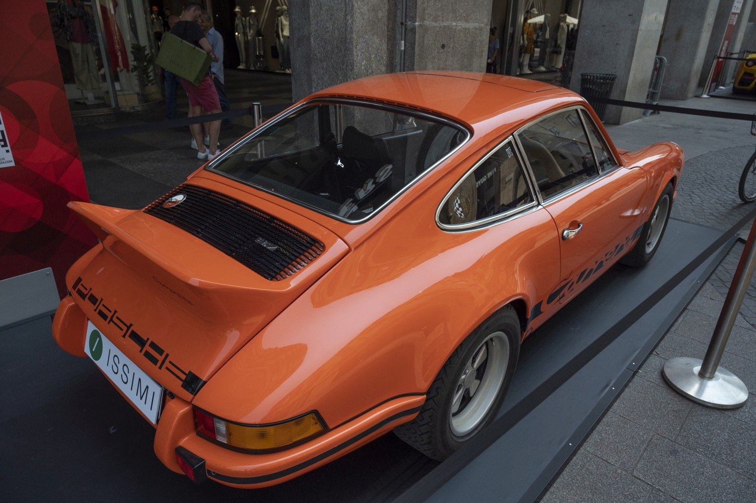 Rear and side view with whale tail spoiler and orange paint.