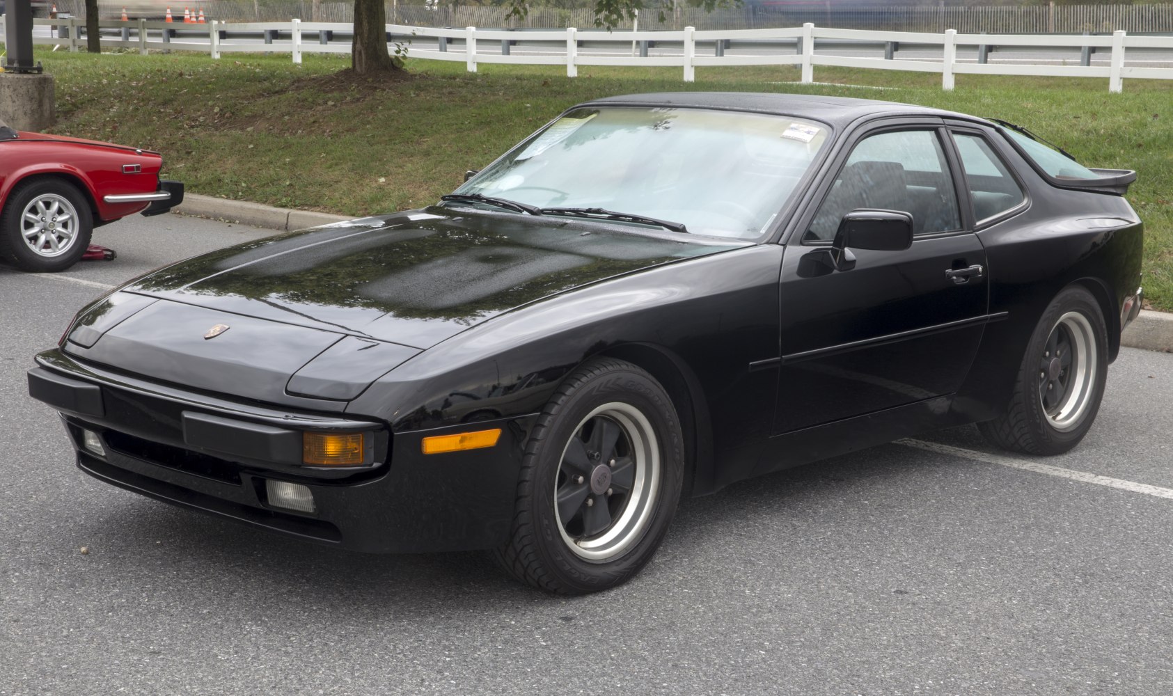 Front-side view of classic black sports coupe with pop-up headlights and alloy wheels