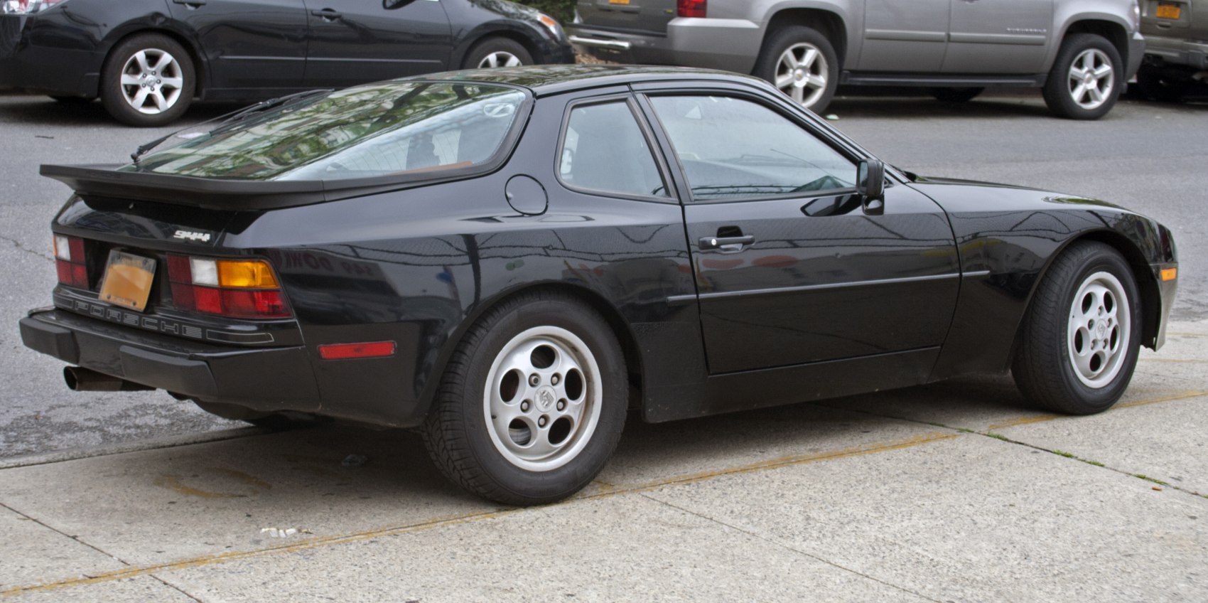 Rear-side view of a sports coupe with rear spoiler and alloy wheels