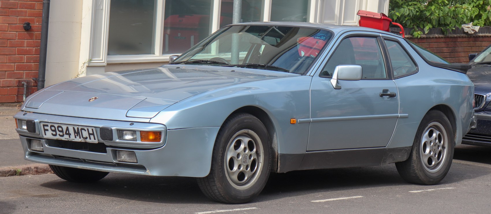 Classic sports coupe front side profile with pop-up headlights and alloy wheels