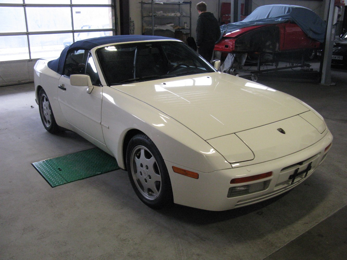 White convertible with pop-up headlights and blue soft top roof